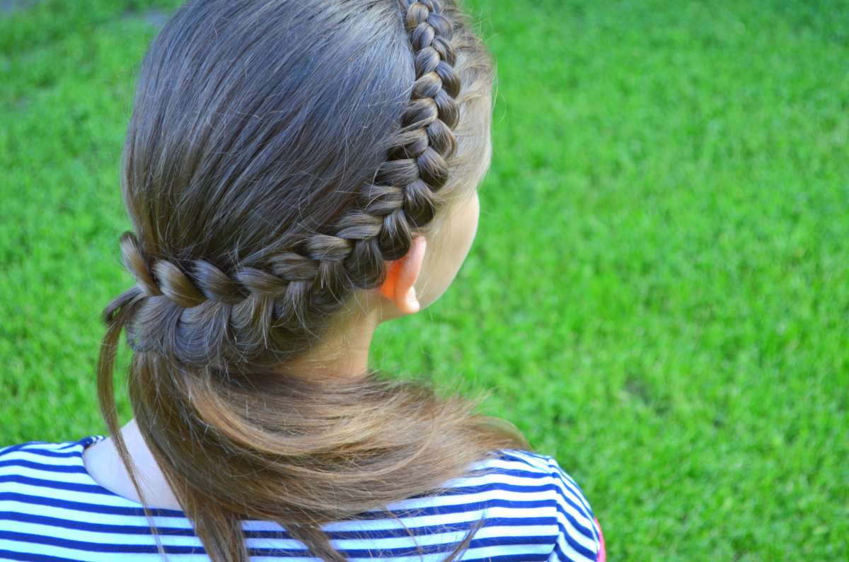 Back of head with a braided hairstyle running in a semicircle from top right to bottom left