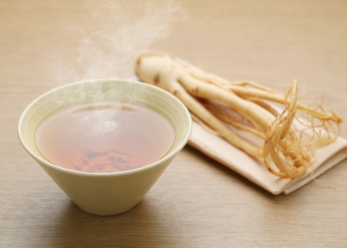 Ginseng root beside a cup of hot ginseng tea