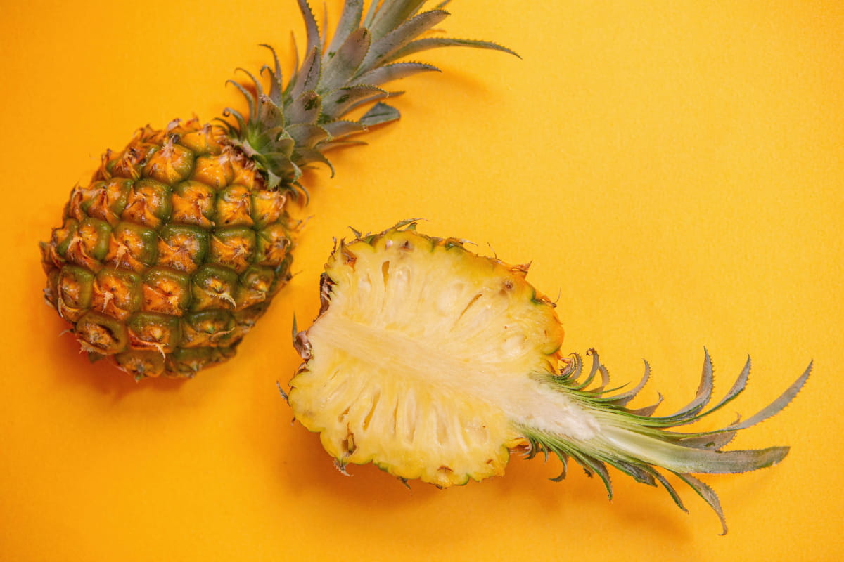 Halbierte Ananas auf gelbem Hintergrund