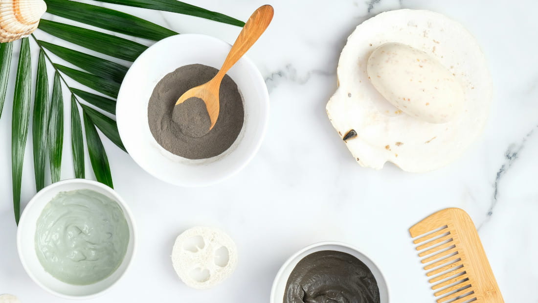 Top view of various spa items on marble; mixtures for clay masks that can be made with bentonite.