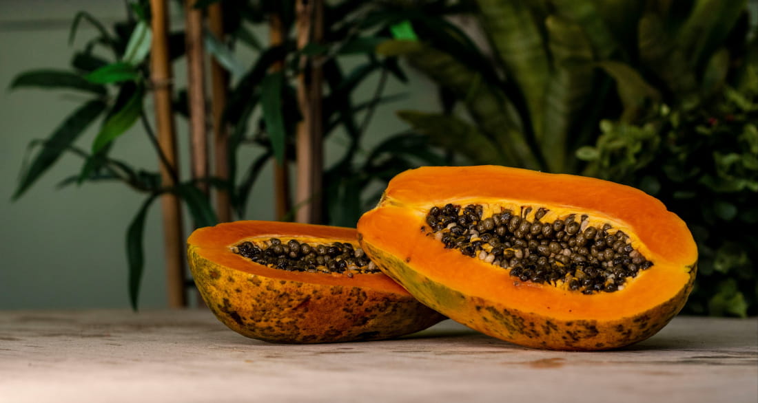 Halved papaya against a bamboo background