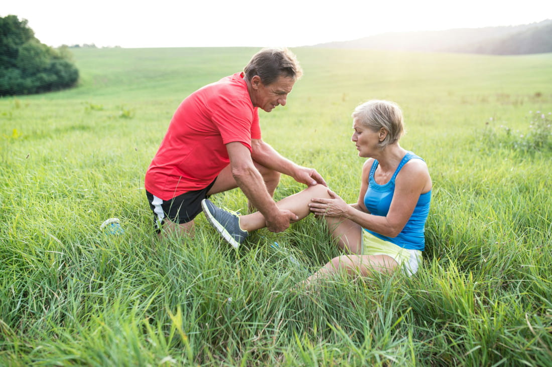 Two people on the grass, one holding the other's knee