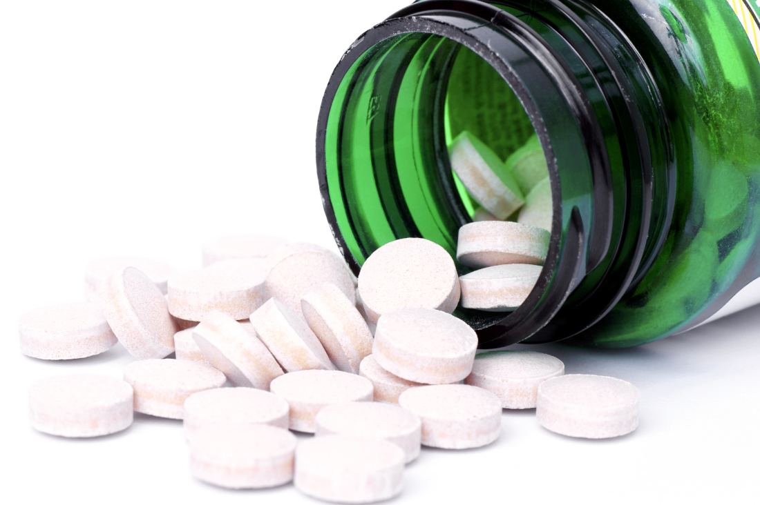 Glas mit ausgeschütteten Tabletten