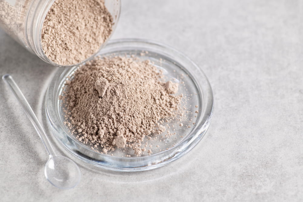 Fine powder in a glass bowl, with spoon beside